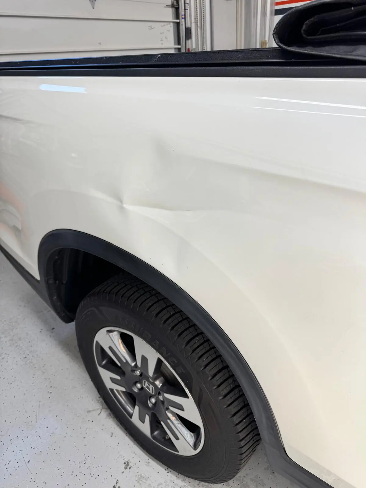 Before — white SUV dent