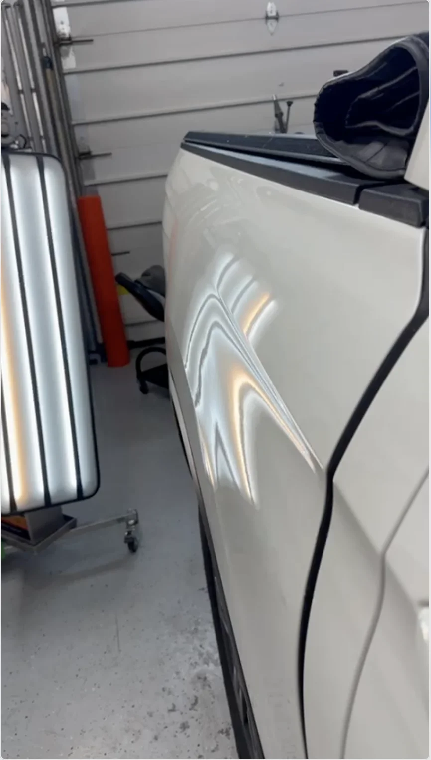 After — hail dent on white SUV repaired